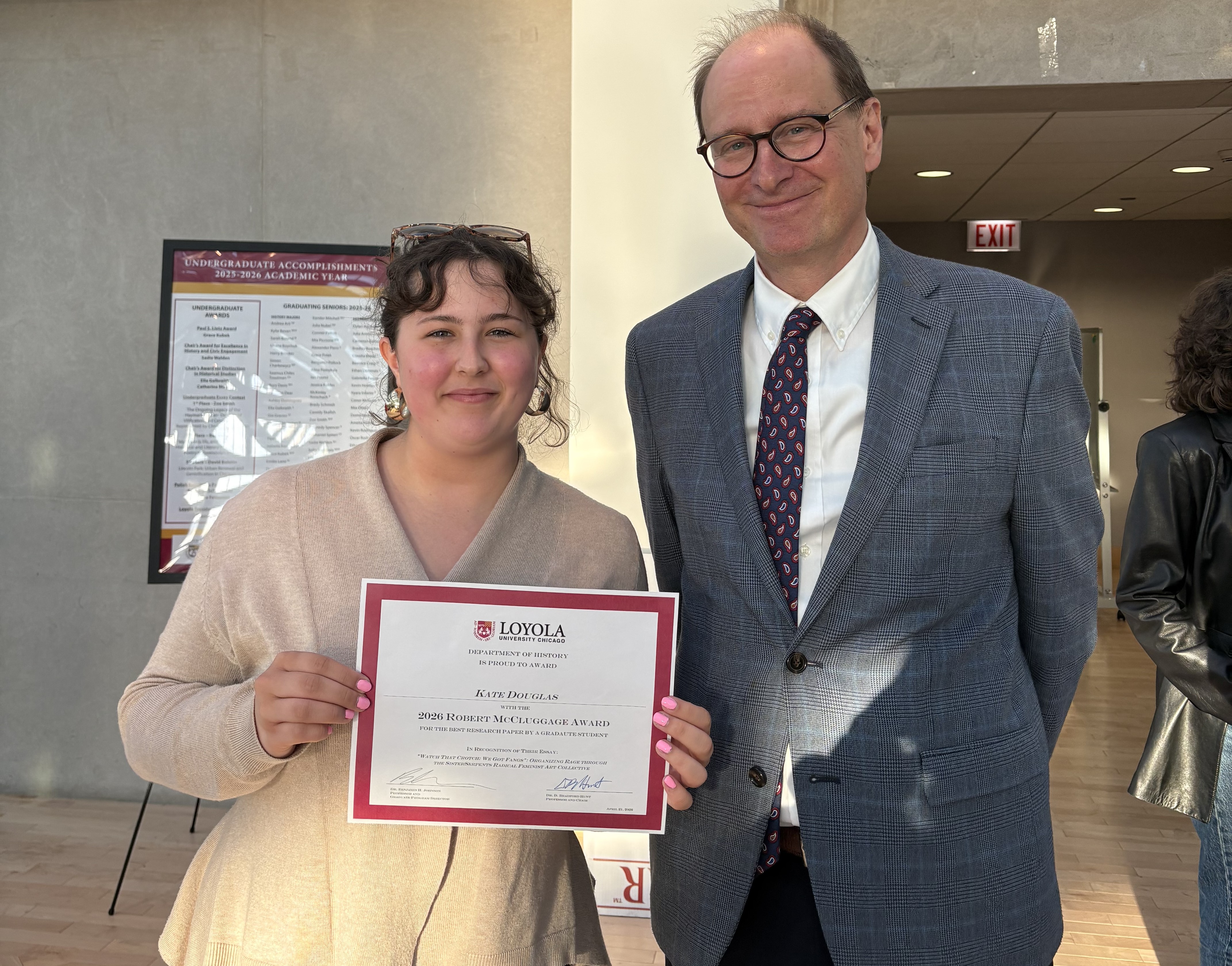 Kate holding a certificate standing next to Dr. Bradford Hunt
